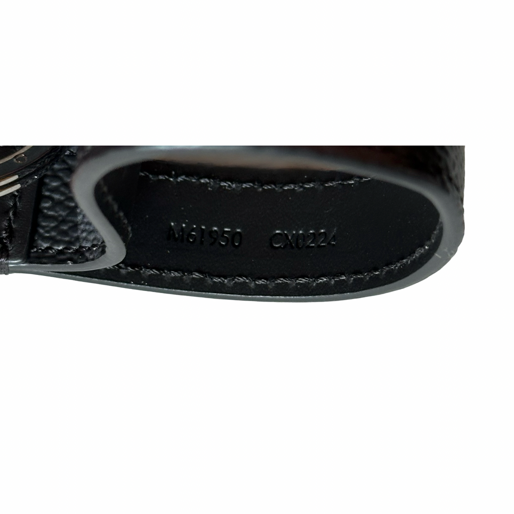 Close-up of a black leather product with visible branding on a white background